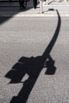 Minimalism shadow traffic light on asphalt street pavement showing urban safety in daytime with clean lines and subtle texture for mobility themes