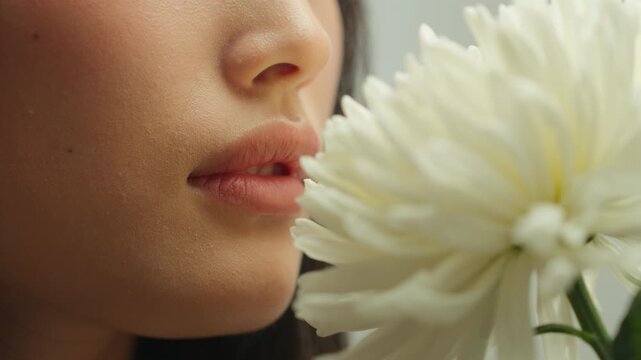 Closeup face Asian woman girl unrecognizable female smelling flower white chrysanthemum fresh aroma delicate fragrance organic cosmetics peaceful wellness floral harmony beauty perfume spring season