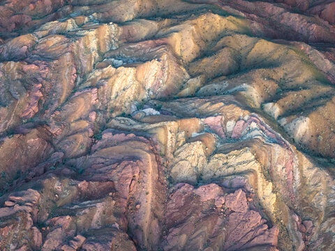 Aerial view of the terrain's vibrant layers weaving through earthy tones, a textured tapestry of nature's artistry, Indio, California, United States.