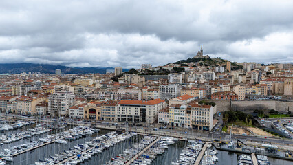 Naklejka premium Vue emblématique du Vieux-Port de Marseille avec ses bateaux, ses quais animés et son ambiance maritime typique au cœur de la ville.