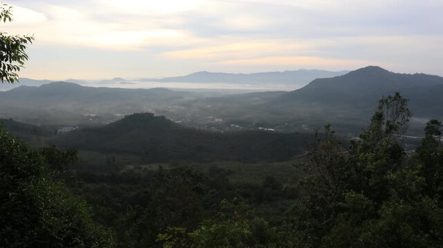 Natural video background of a high-angle atmosphere on a mountain that overlooks the surrounding scenery(mountains, trees,sea)from a scenic vantage point,with a wooden chair for sitting and resting