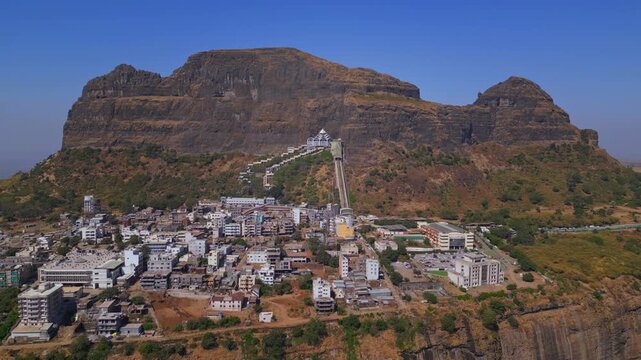 Forward moving drone shot of Saptashrungi Devi Temple, one of the revered Sadetin Shakti Peethas in Maharashtra, capturing the hilltop shrine, surrounding mountains in Vani, Nashik