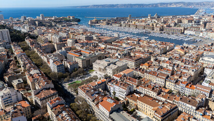 Obraz premium Vue emblématique du Vieux-Port de Marseille avec ses bateaux, ses quais animés et son ambiance maritime typique au cœur de la ville.
