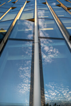 Symmetrical perspective of a modern glass skyscraper facade with vertical reflections creating a strong corporate architecture background for business success and growth