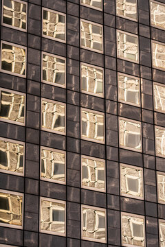 Abstract repetition of window squares across a modern facade creating rhythmic grid texture for corporate architecture and business background applications