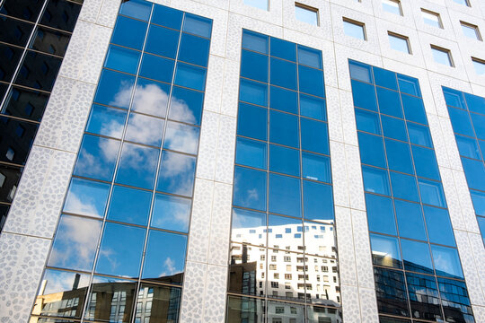 Glass office building facade with window reflections forming a clean corporate pattern in modern architecture ideal for business branding and abstract background use