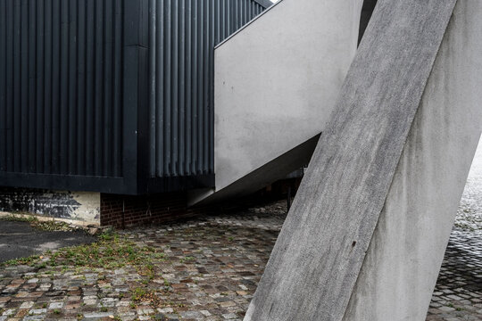 Abstract exterior architecture showing concrete industrial corner with modern metal texture and diagonal structure beside pavement for urban design