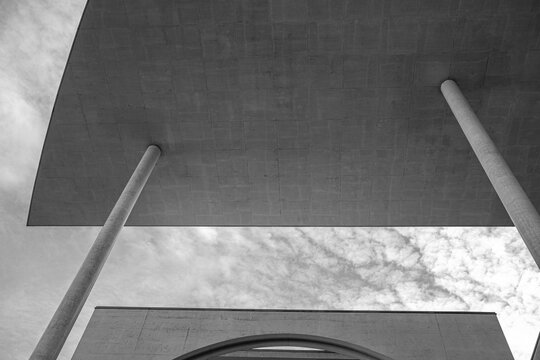 Concrete architecture canopy with modern column structure in minimal geometry under wide sky where shadow shapes create calm architectural mood