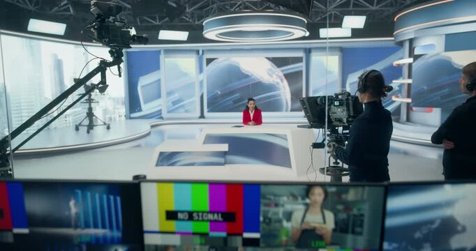 Backstage TV Station Production Control Room Manages a Live News Channel as Technicians Monitor Multiview Screens, Feeds, Coordinate Broadcasts. Camera Elevate Zoom into News Studio with Presenter