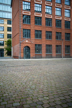 Brick building facade with windows and courtyard in daylight showing urban architecture perspective texture and clean copy space background template