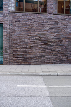 Urban street wall with brick facade texture and pavement creating minimal background with clean copy space for design branding template