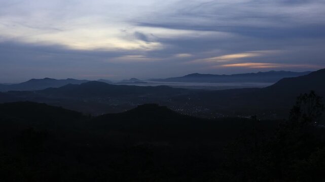 Natural video background of a high-angle atmosphere on a mountain that overlooks the surrounding scenery(mountains, trees,sea)from a scenic vantage point,with a wooden chair for sitting and resting