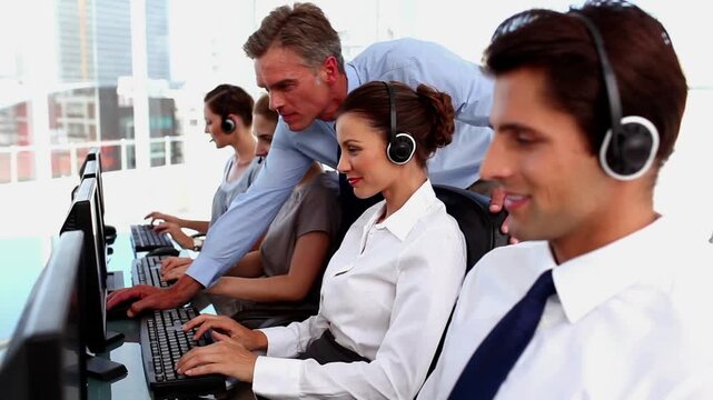 Animation of abstract pattern over caucasian manager assisting call center agent working on computer
