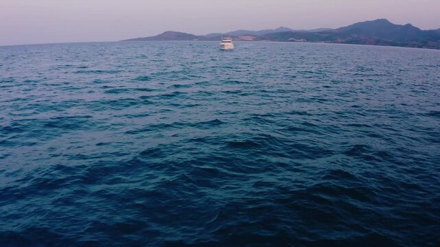 Cinematic Drone Reveal Shot Over Dark Sea Toward Luxury Yacht at Dusk