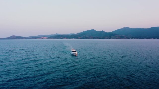 Front View of Luxury Yacht Navigating Mediterranean Sea with Mountain Backdrop