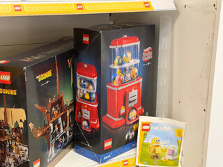 Obraz premium Boxed lego sets on store shelf with red gumball machine model