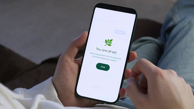 Successful Wellness App Session Booking on Smartphone. Close-up of hands holding a phone with a You are all set confirmation. Ideal for mental health, meditation, and self-care content. 