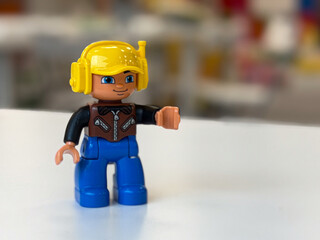 Fototapeta premium Yellow-helmet toy figure on white surface