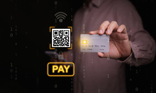 Online payment concept. A businessman holding a credit card with QR code and pay button graphics. Fintech, e-commerce, digital shopping technology, and wireless secure electronic banking transaction.