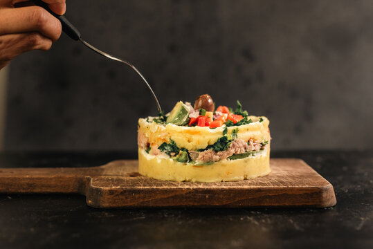 A fork on top of a traditional Peruvian dish called Causa rellena.