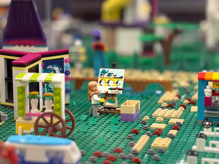 Fototapeta premium Lego artist painting in miniature market scene