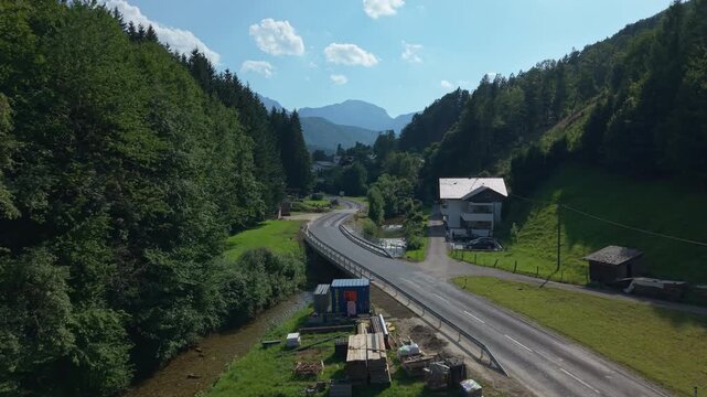 Aerial shot of Aurach river, mountain road and alpine valley in Neukirchen