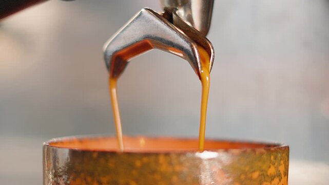 Freshly Ground Coffee Pouring into Cup from Portafilter to make Flat White. High Quality Slow Motion Clip of Professional Barista Made Hot Morning Drink.