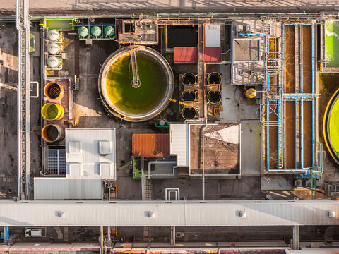 Aerial view of the industrial complex showcases geometric precision and contrasting textures, where circular tanks meet linear structures, Atessa, Abruzzo, Italy.