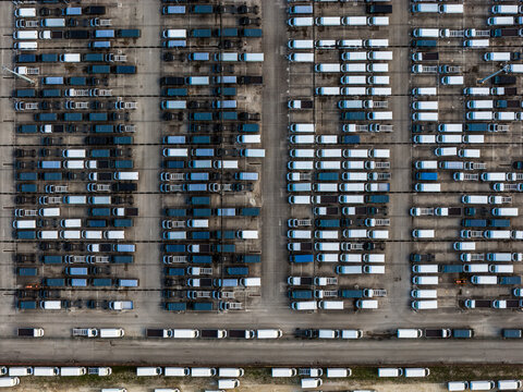 Aerial view of neatly arranged rows of trucks creating a stark contrast between their dark and light-colored roofs, Atessa, Abruzzo, Italy.