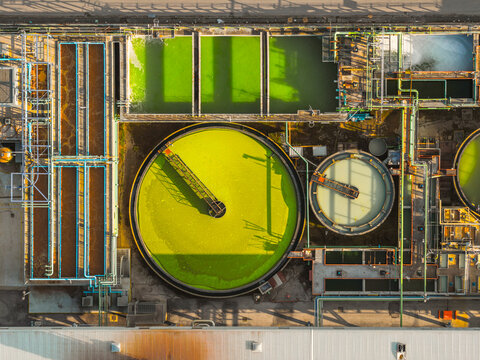 Aerial view of the geometric patterns of the wastewater treatment facility, a symphony of lime green and azure pipes against the somber concrete, Atessa, Abruzzo, Italy.