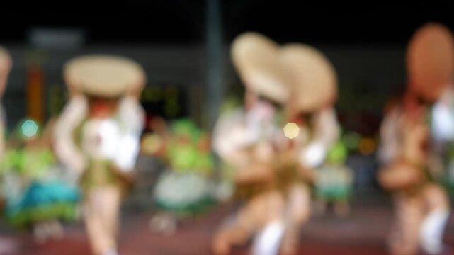 Cultural dancers in traditional costumes from nearby towns perform their practiced dance steps at a government-sponsored trade fair held in the public grounds. Blurs