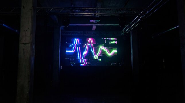 Vibrant neon audio waveform glowing in blue purple concept. Vibrant neon sound wave visual in a dark industrial space.