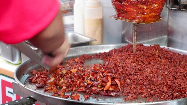 Popular Middle Eastern street food consisting of marinated chicken, lamb, beef, or mixed meats stacked in a cone shape on a vertical rotisserie, sold on  the street
