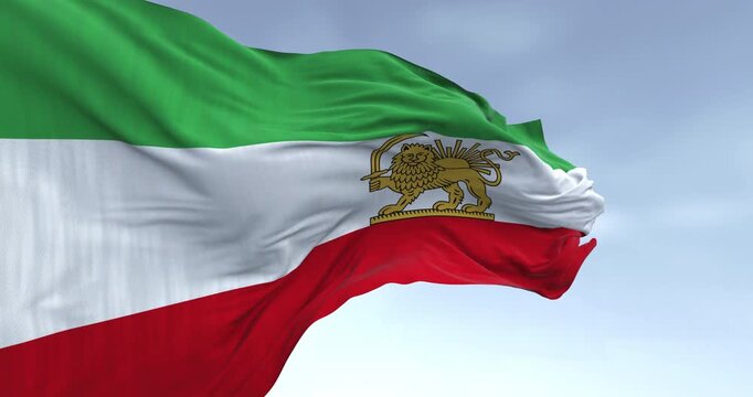 Iran Pahlavi era Lion and Sun flag waving against blue sky