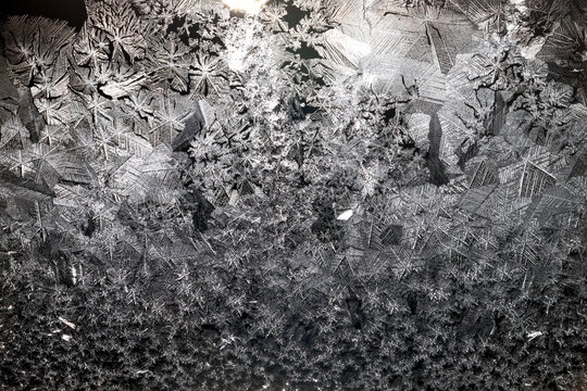 Ice crystals freezing on a black background, abstract winter photo surface
