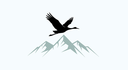 Fototapeta premium Silhouette of a majestic crane bird flying over snowcapped mountains.