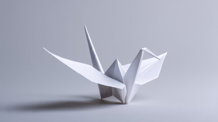White origami crane against low light, a paper bird symbolizing peace, hope and Japanese art tradition