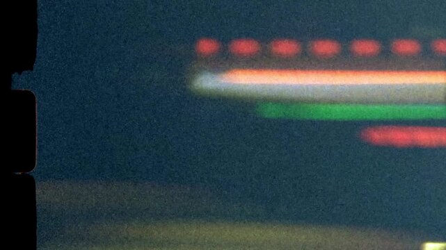 Super 8mm vintage abstract traffic lights streak across the screen at night