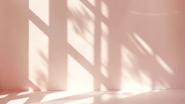 Light enters a room and casts shadows on a light pink wall and floor. This creates a visual contrast as the shadows move. The time is midday with clear sunlight