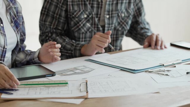 Engineers, architects, and technicians are analyzing structural design drafts in meetings with tabletop blueprints and discussing the project collaboratively in office meetings.