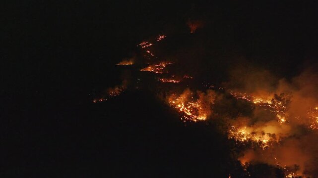 France - Reunion Island - Volcanic eruption, lava in the forest going to the sea - flyng backward