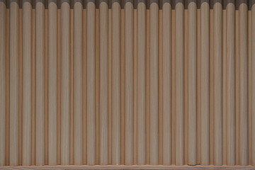 Vertical fluted wood panel texture. Modern interior wall cladding with light brown wooden slats in a seamless pattern. © Okta