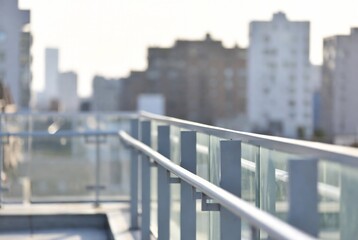 Fototapeta premium A balcony overlooks a city skyline. A person is standing on the balcony, looking out at the buildings. New York City.
