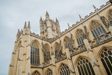 Fototapeta premium Bath England: 27th July 2025: look up at Bath Abbey's tall stone structure featuring intricate designs. The scene captures the impressive size and craftsmanship of this historic church