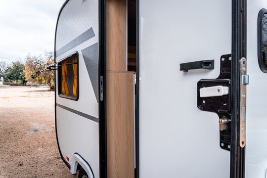 Camper door opening, displaying the interior and an open window, highlighting features of recreational vehicle travel and camping