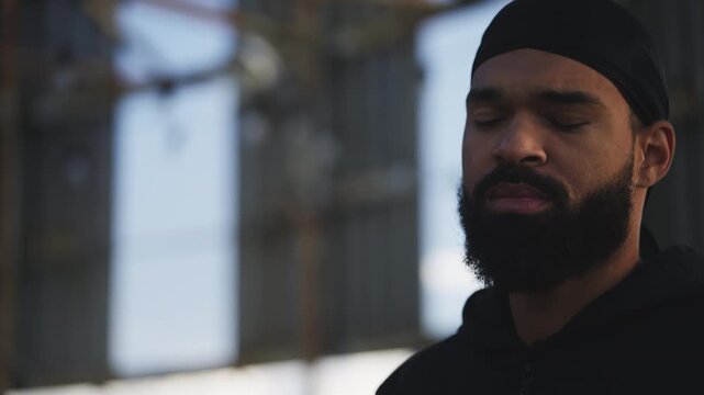 African American man in a durag smoking cigarette on rooftop, bad habits