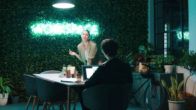 Night, people and conversation in office with laptop, web design idea or research for creative project. Digital designer, team and collaboration in agency with computer, planning or site development.