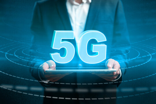 5G technology demonstration in office with user holding tablet and glowing signs