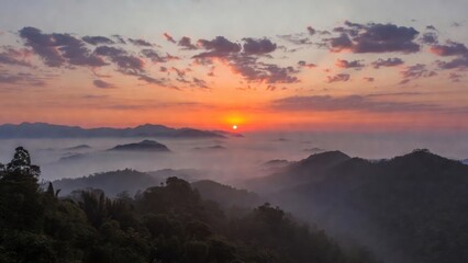 Naklejka premium Sun rising over misty mountain ridges at dawn panorama