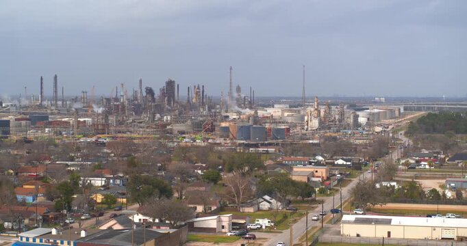 Establishing reveal shot of homes near heavy industry and chemical plants in the Baytown, Texas area